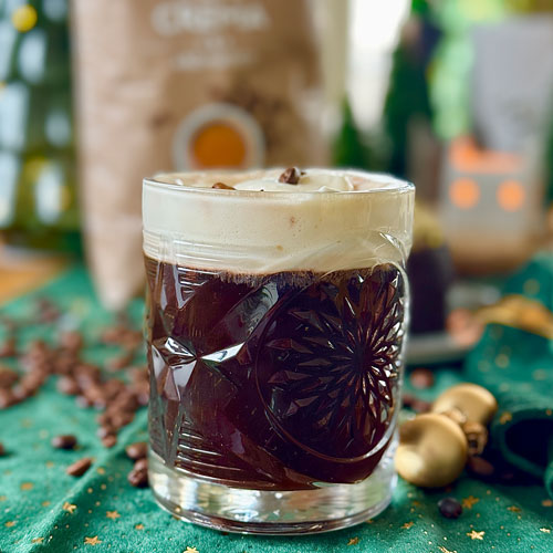 Ein kleines Glas schwedischer Kaffeepunsch mit weihnachtlicher Dekoration