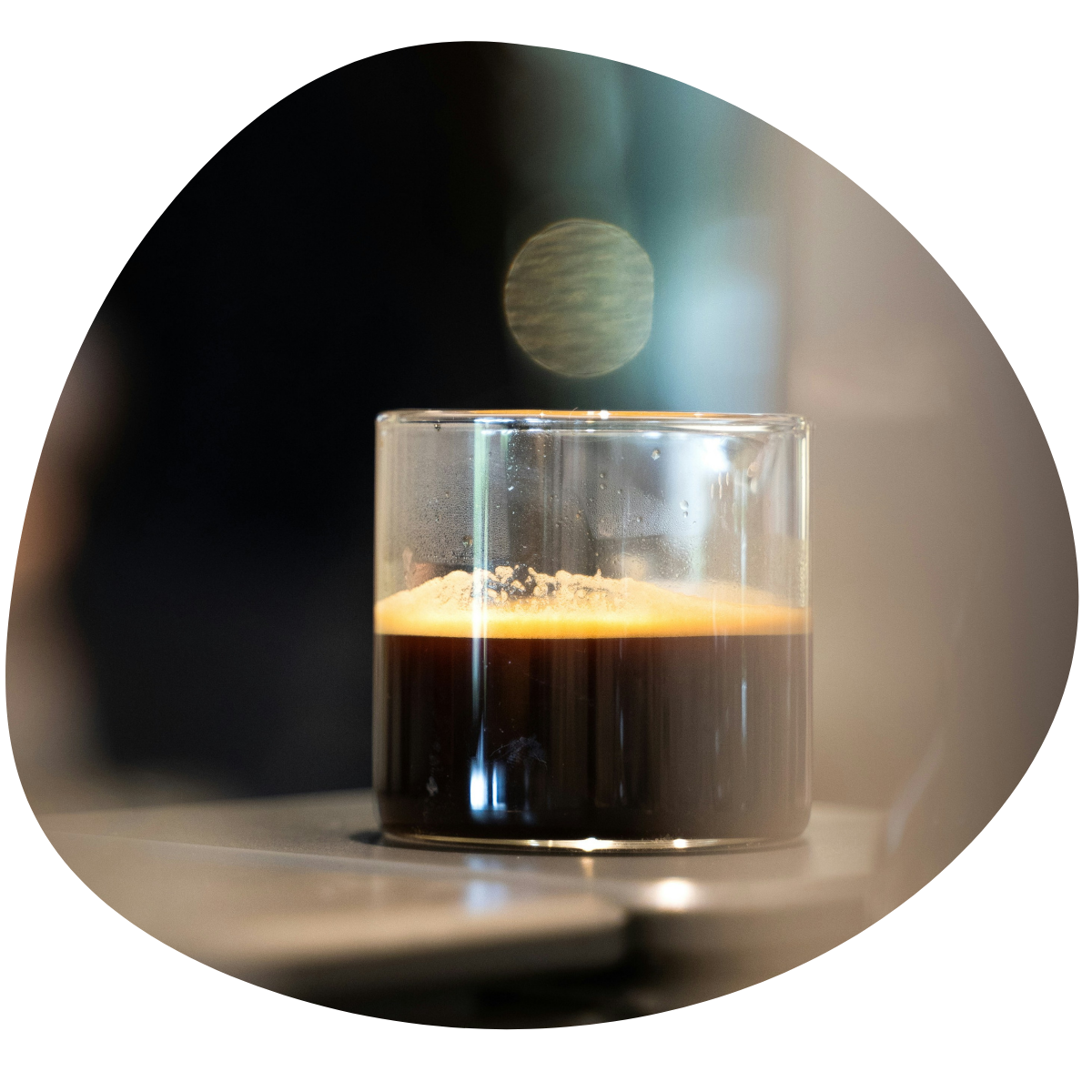 Ein cafe corretto in einem Glas auf einem Tisch