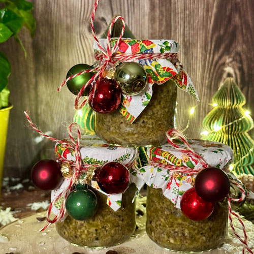 Drei Marmeladegläser gefüllt mit Pesto und weihnachtlicher Dekoration