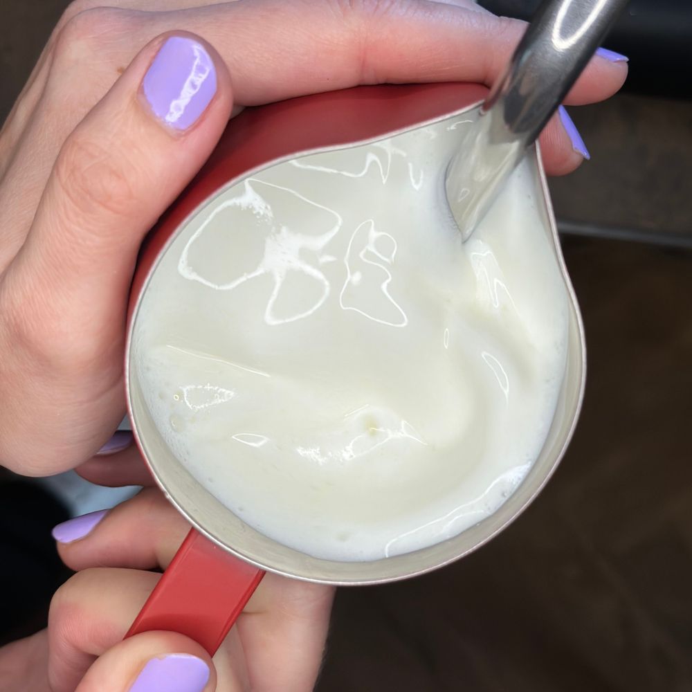 Milch wird im Milchkännchen aufgeschäumt