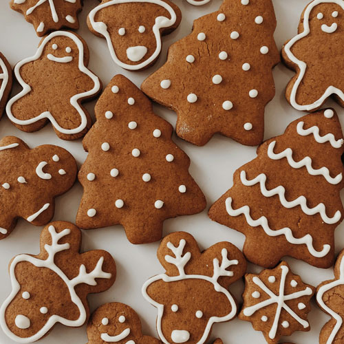 mehrere Lebkuchen in Form von Männern, Tannenbäumen und Rentieren, dekoriert mit Zuckerglasur