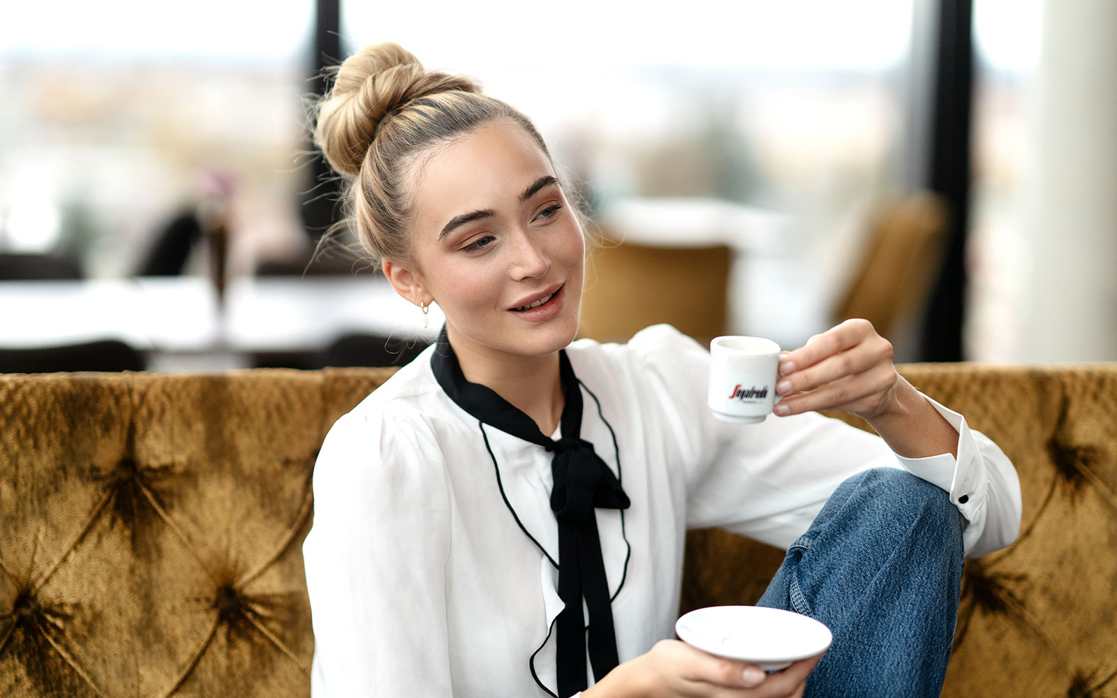 Eine blonde Frau trinkt Ristretto aus einer Segafredo Tasse