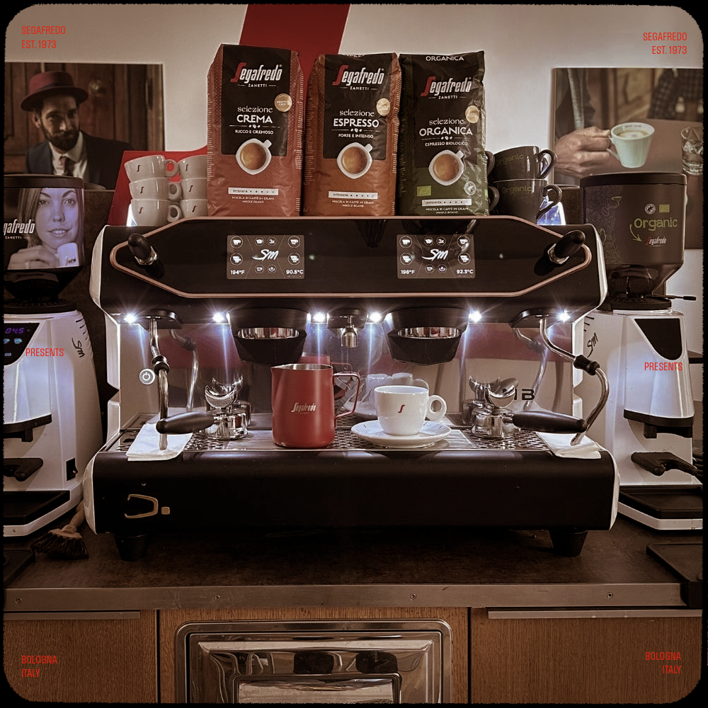 Eine Kaffeemaschine mit Kaffeebohnen, Milchkännchen und Cappuccino-Tassen